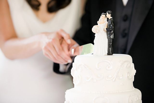 Wedding cake bride and groom Getty Bride and groom cut into their wedding cake (stock photo)